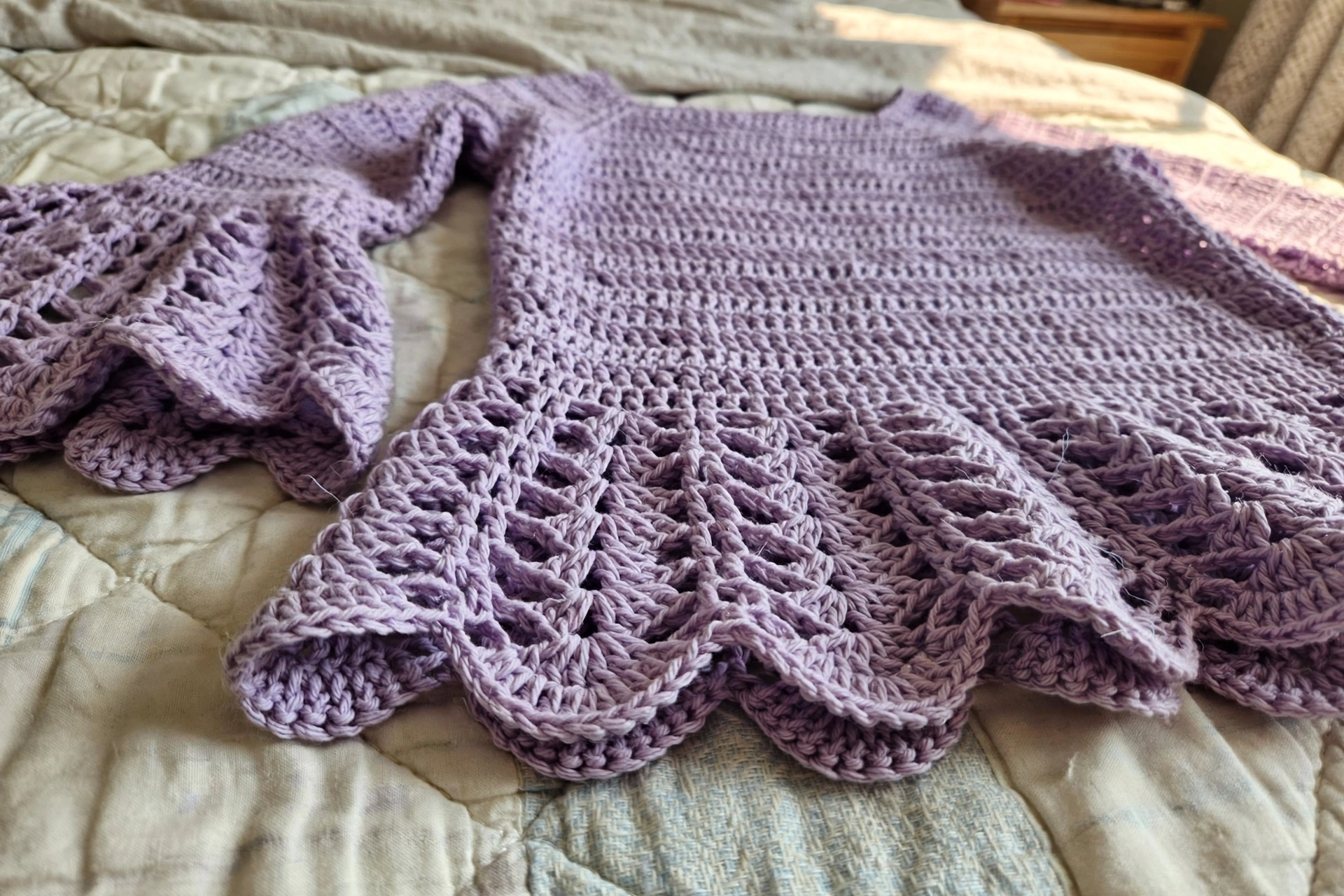 Close-up of the shell stitch motifs and scalloped peplum hem on the lavender fairy top