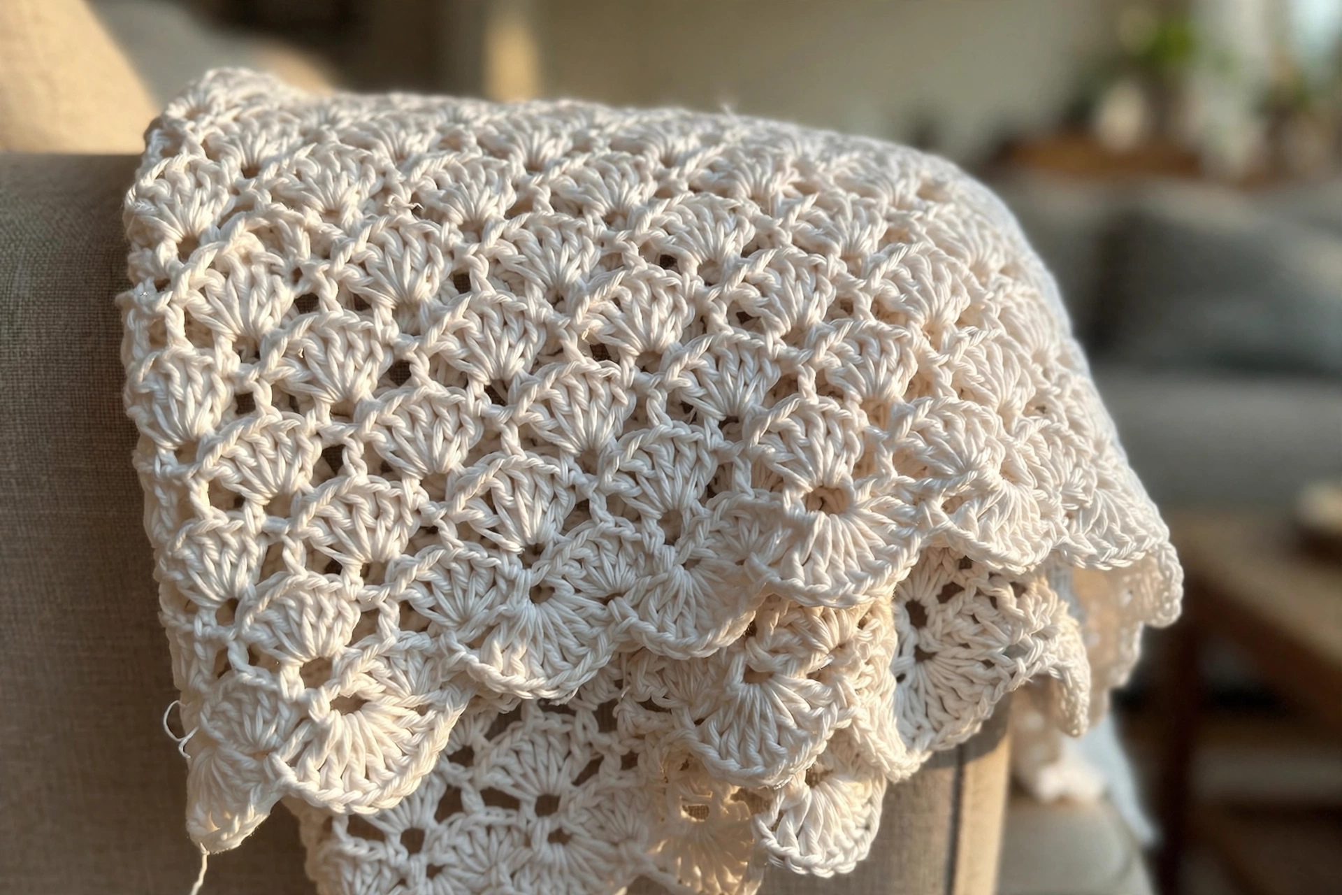 Close-up of the open flower-petal lace stitches on the white baby blanket