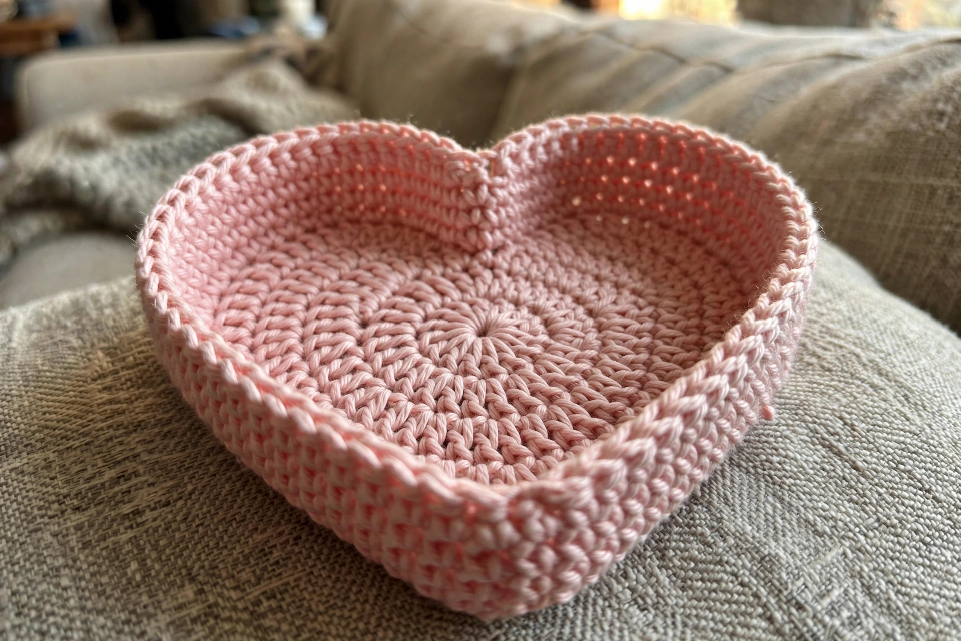 Close-up of the heart shape and stitch texture of the pink crochet trinket dish