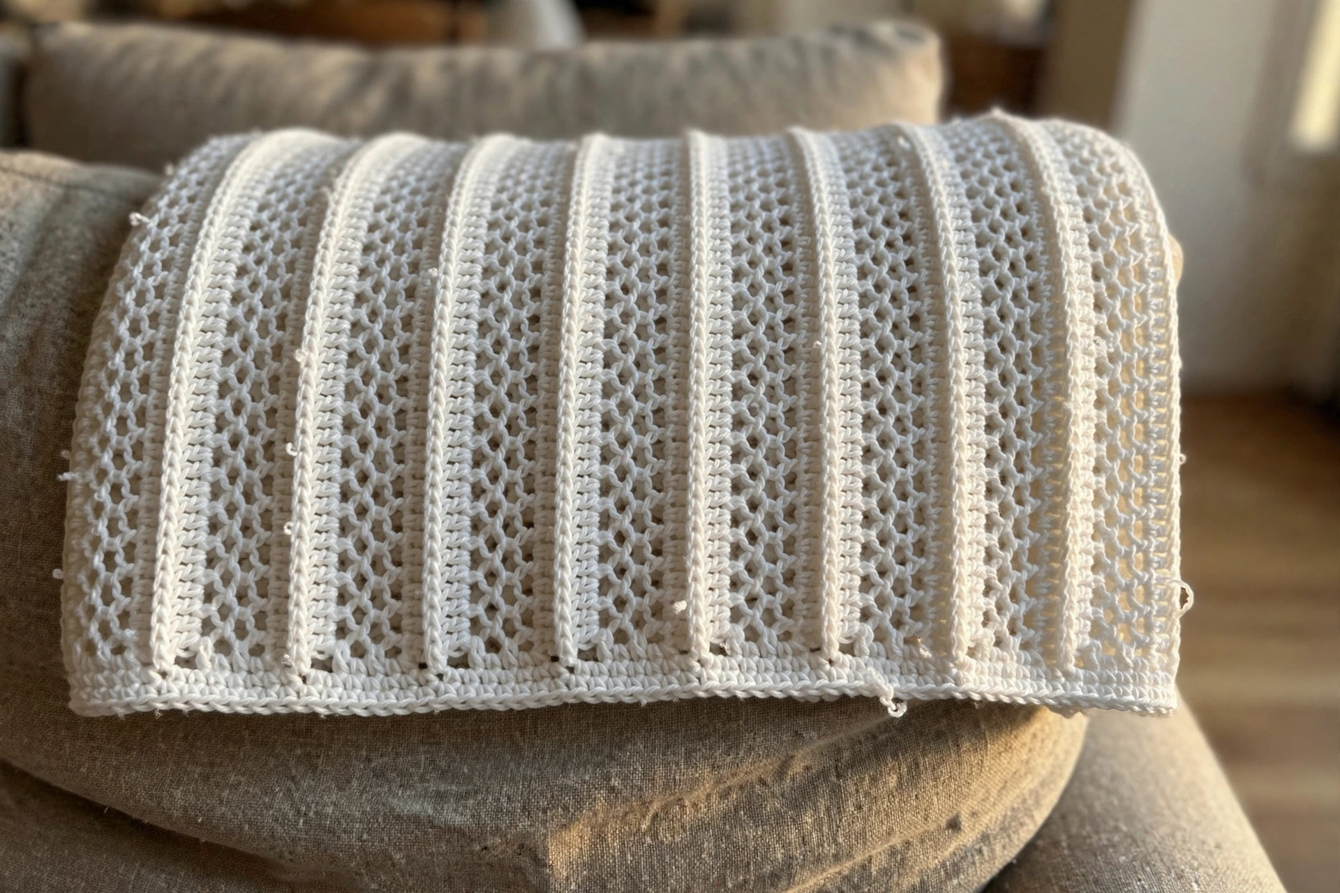 Close-up of the honeycomb Tunisian stitch texture of the white baby blanket