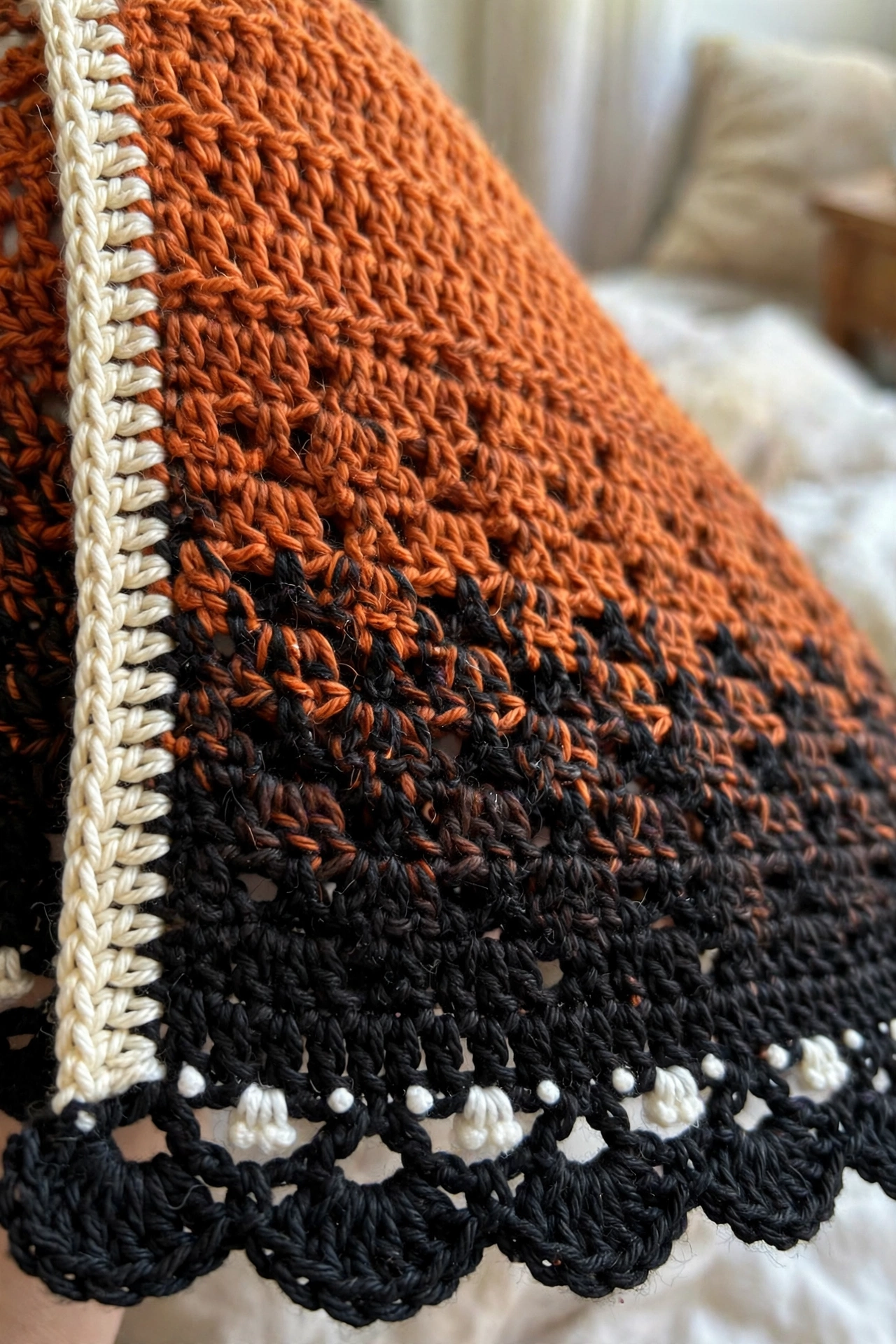 Close-up of the tapestry crochet colorwork, cream body stripe, and white-dotted scalloped border on the monarch butterfly shawl