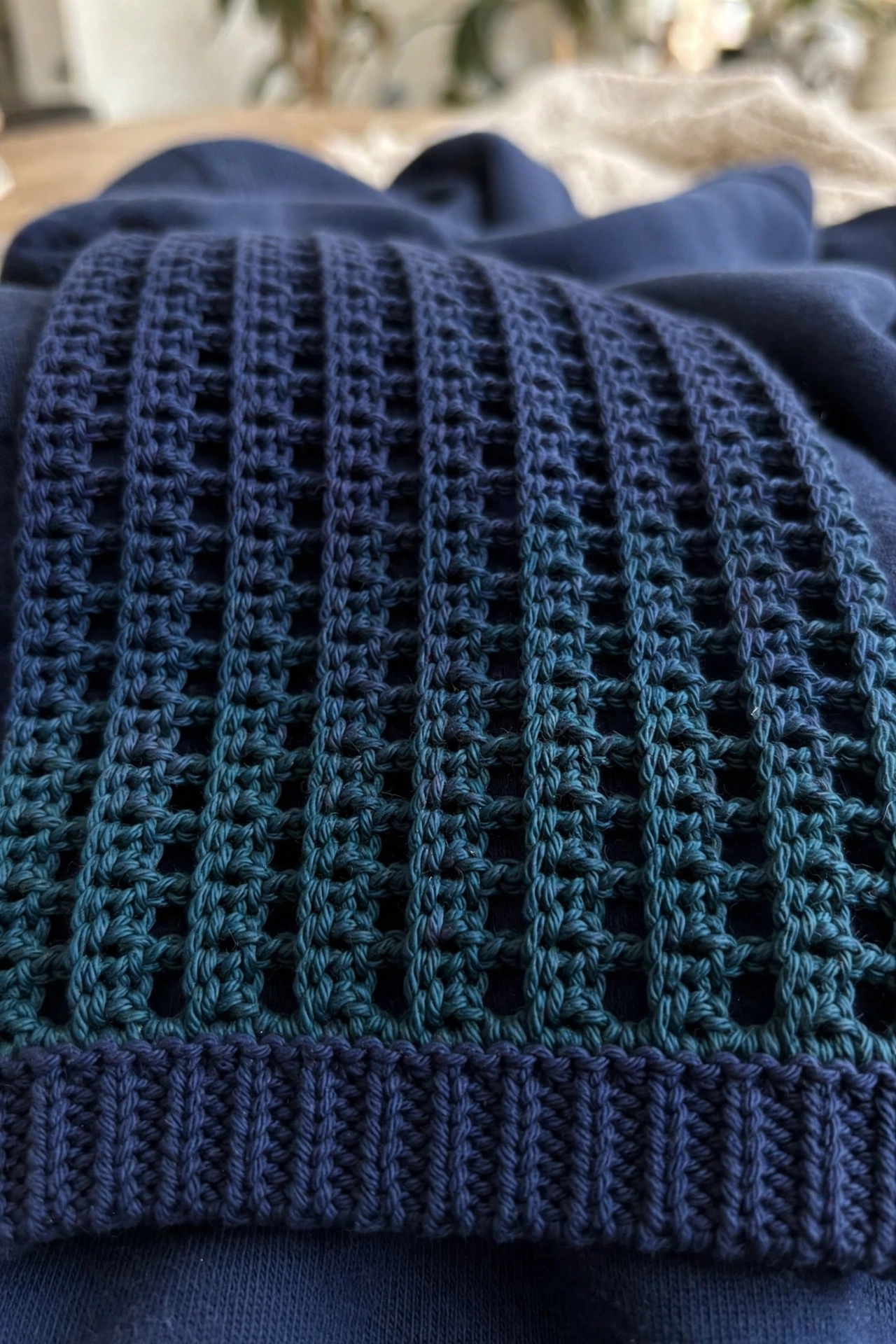 Close-up of the ombre granny mesh stitches and ribbed cuff on the ocean breeze cropped hoodie