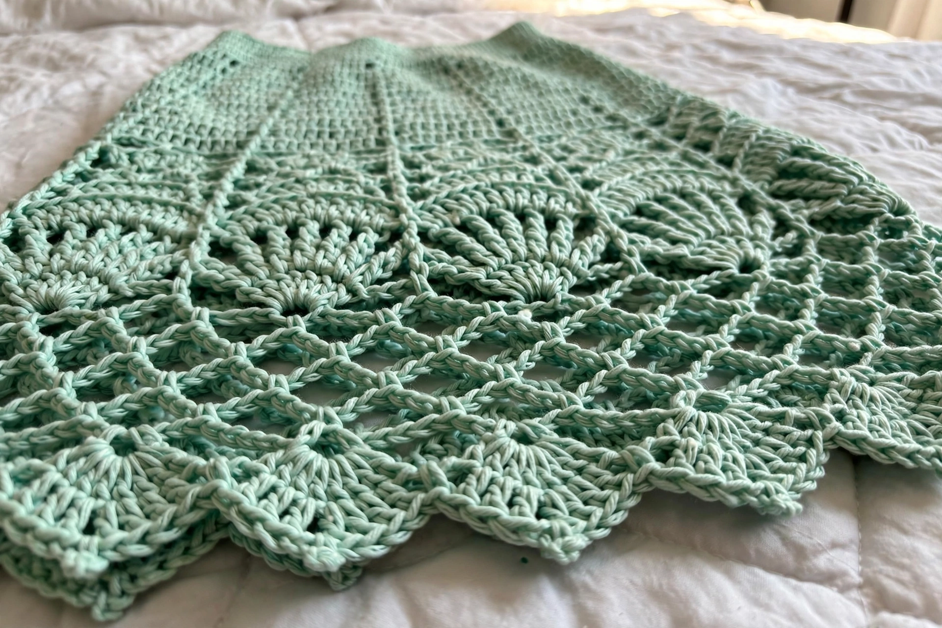 Close-up of the mint green fan-stitch lace skirt with open diamond band and scalloped hem