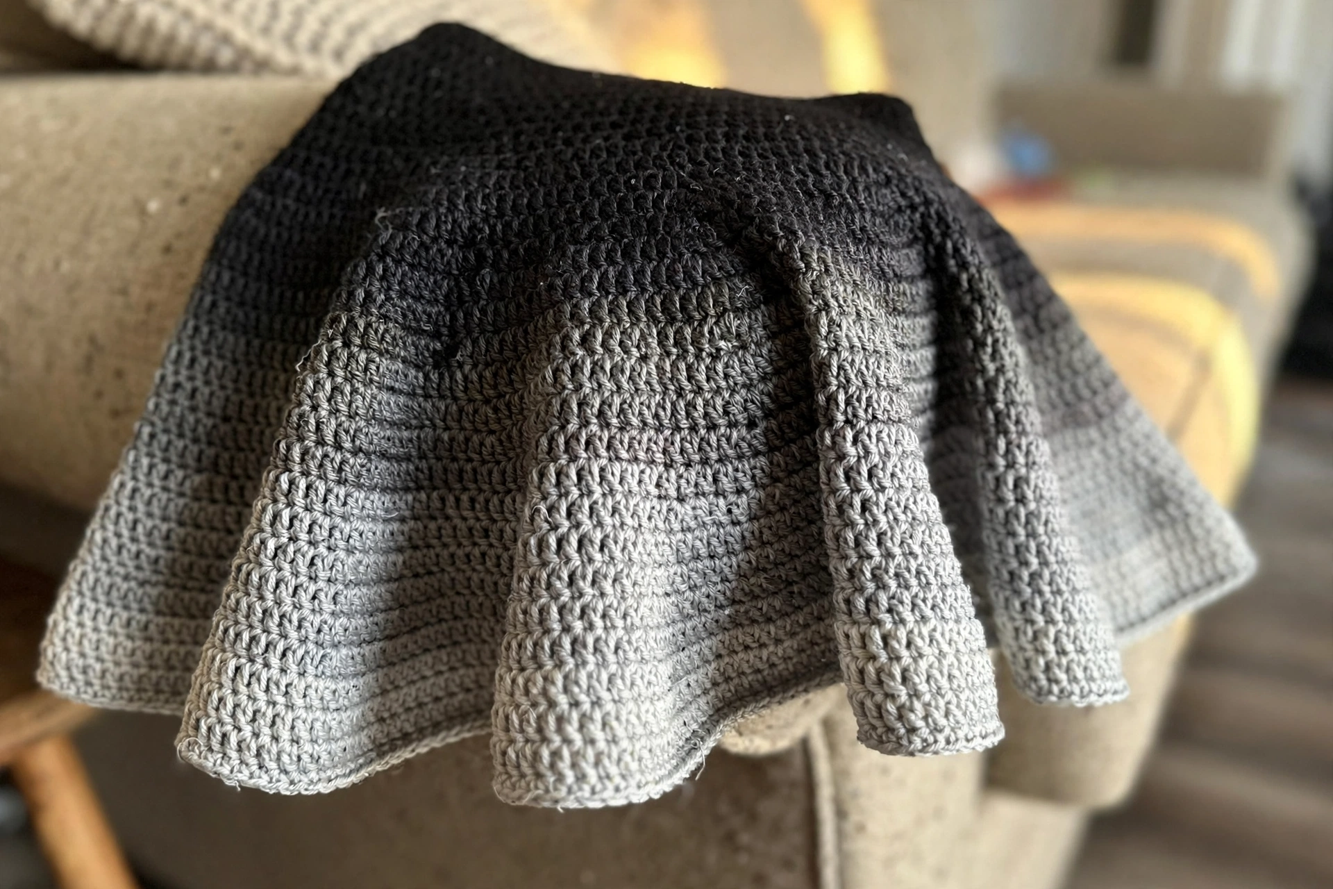 Close-up of the monochrome gradient stripes and flared skirt of the crochet mini dress